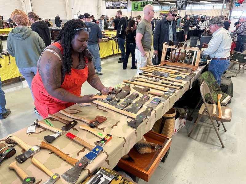 Jennifer Council examines an ax at the "Survival & Prepper Show" in Longmont, Colo., March 2.