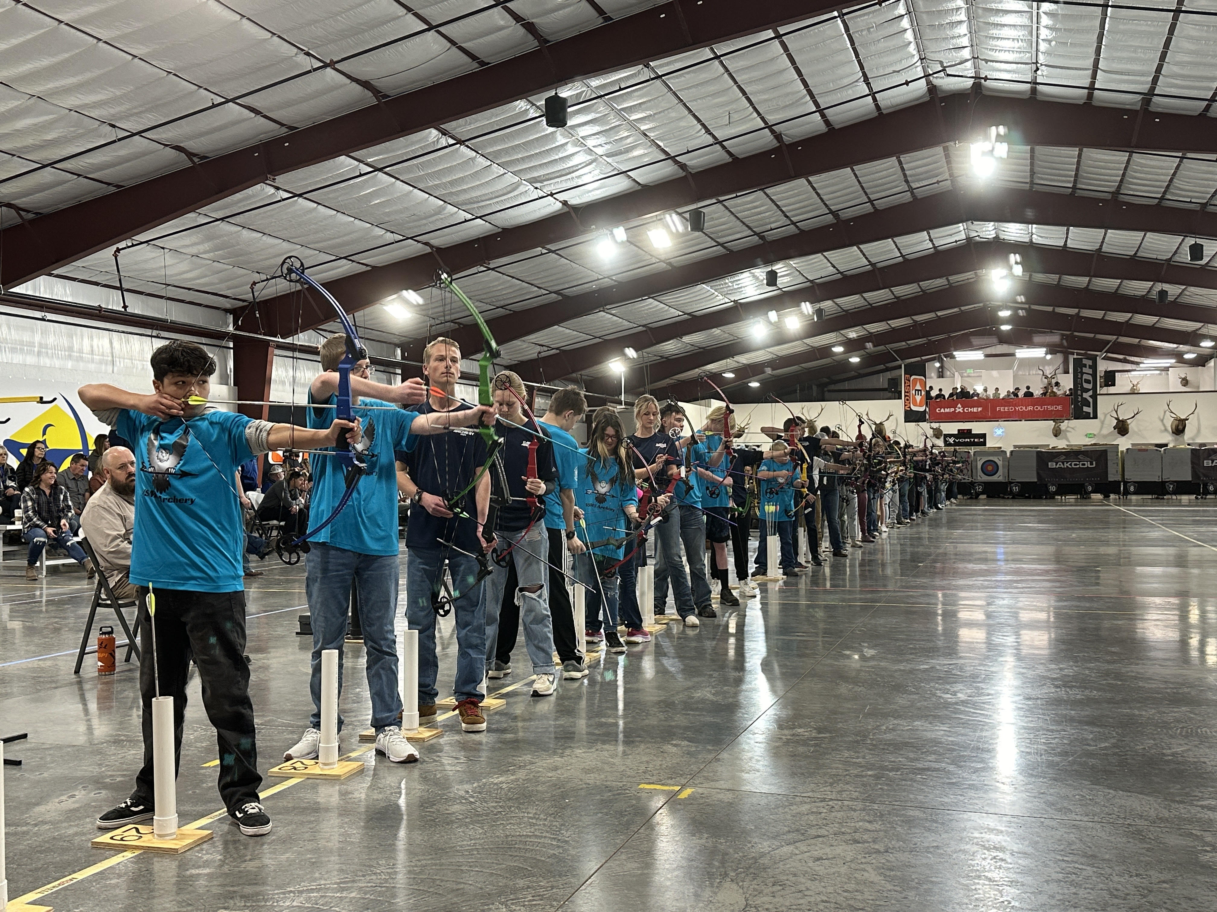 Students line up to shoot at a target 15 meters away at the National Archery in School Program's Utah state tournament Friday at the Weber County Archery Park in Ogden.
