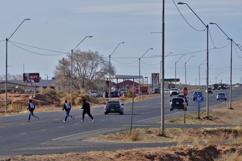 Teens cross Main Street on the Navajo Nation, March 4, in Tuba City, Ariz., just north of U.S. 160. The highway is the de facto border between the Navajo and Hopi Indian reservations and two time zones.