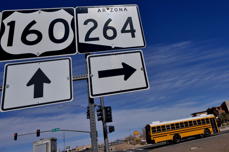 A school bus crosses over U.S. 160 from the Navajo Nation, left, onto the Hopi reservation, right, March 4 in Tuba City, Ariz. U.S. Highway 160 is the de facto border between the Navajo and Hopi Indian reservations and two time zones.