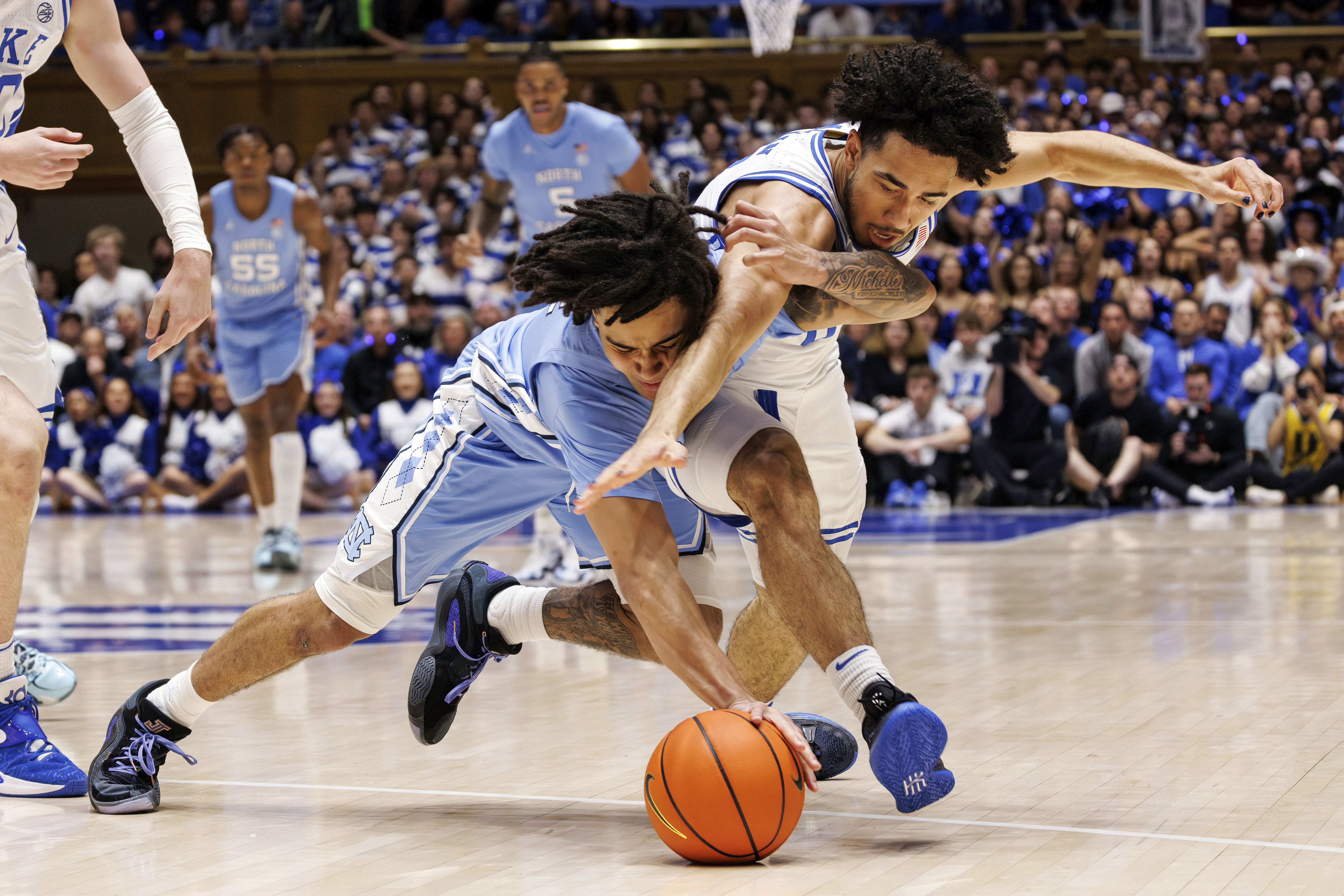 Duke's Jared McCain, right, and North Carolina's Elliot Cadeau, left, battle for a loose ball during the first half of an NCAA college basketball game in Durham, N.C., Saturday, March 9, 2024. 
