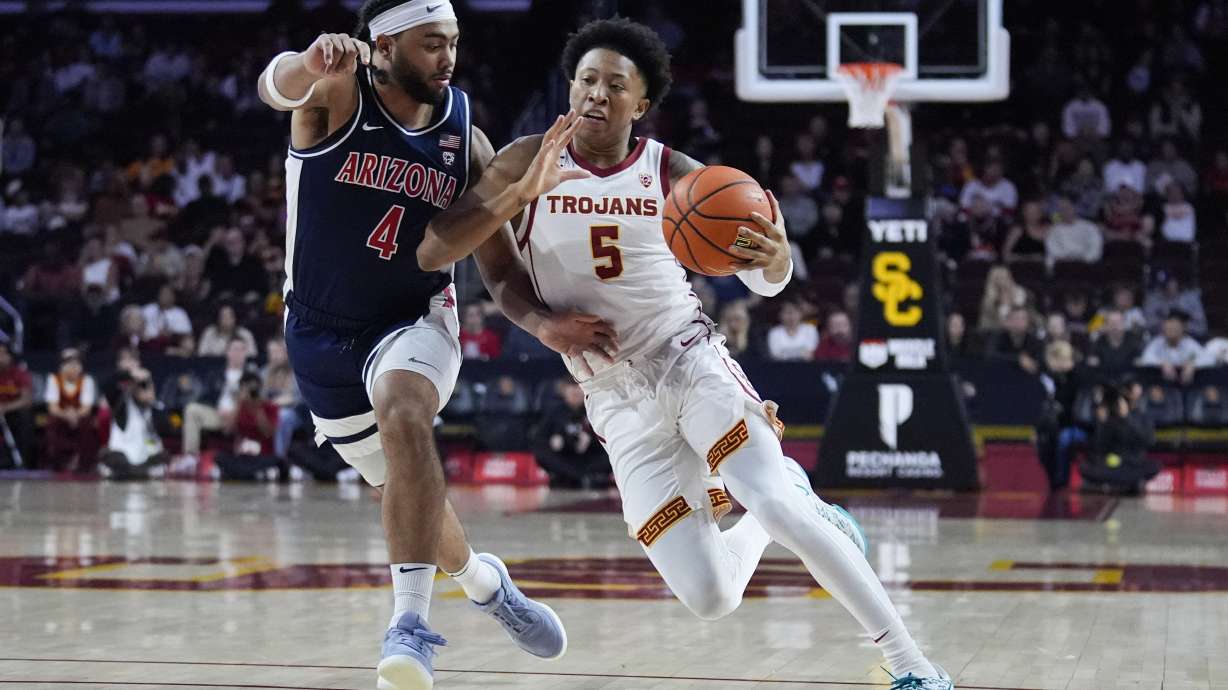 Southern California guard Boogie Ellis (5) is defended by Arizona guard Kylan Boswell (4) during the first half of an NCAA college basketball game Saturday, March 9, 2024, in Los Angeles.
