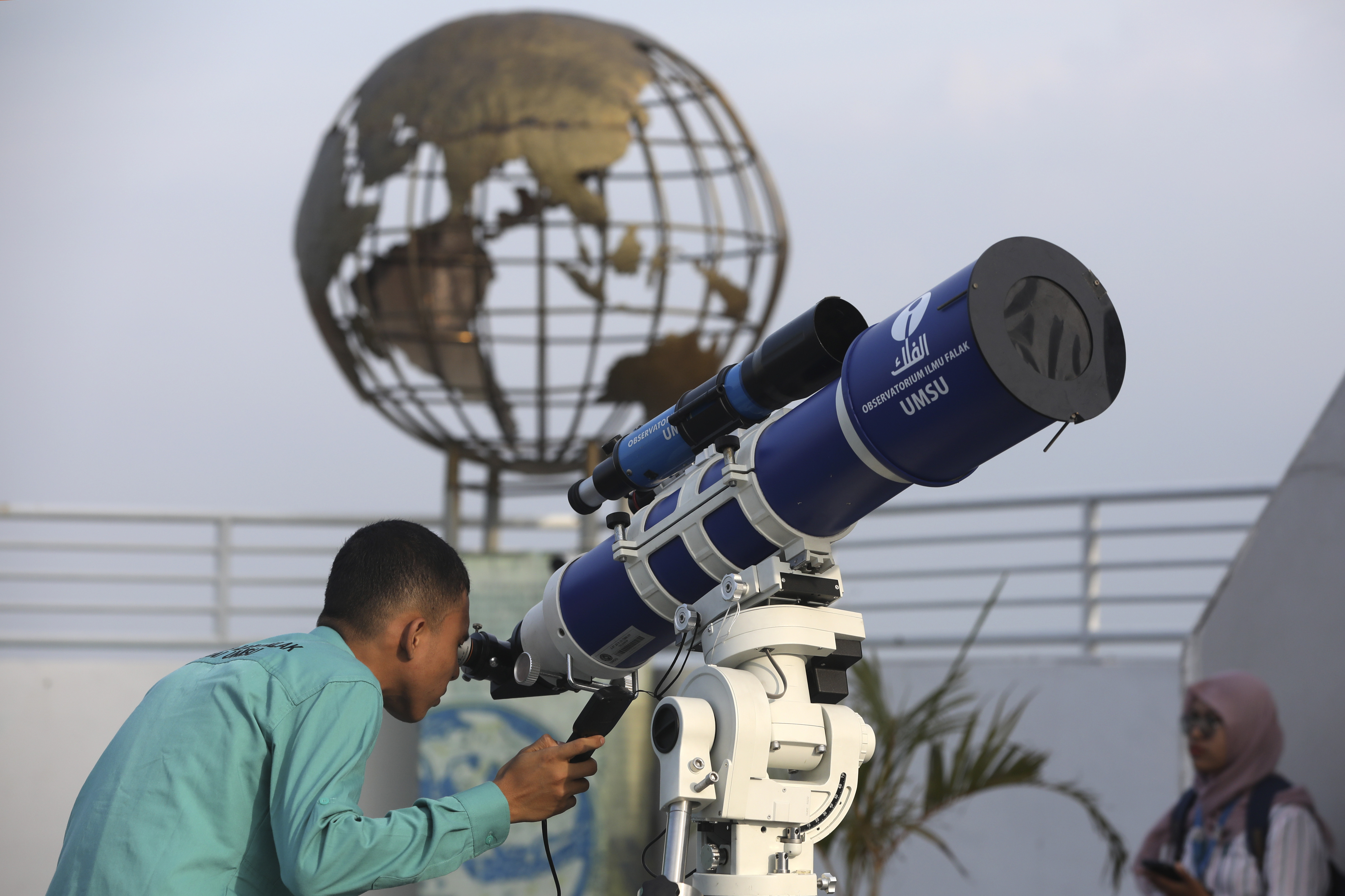 A member of staff uses a telescope to search the sky for the new moon that signals the start of the Islamic holy fasting month of Ramadan, at the Astronomical Observatory of the Muhammadiyah University of North Sumatra in Medan, Indonesia, Sunday. People in the world's most populous Muslim country will start observing Ramadan, the holiest month in the Islamic calendar on March 12.