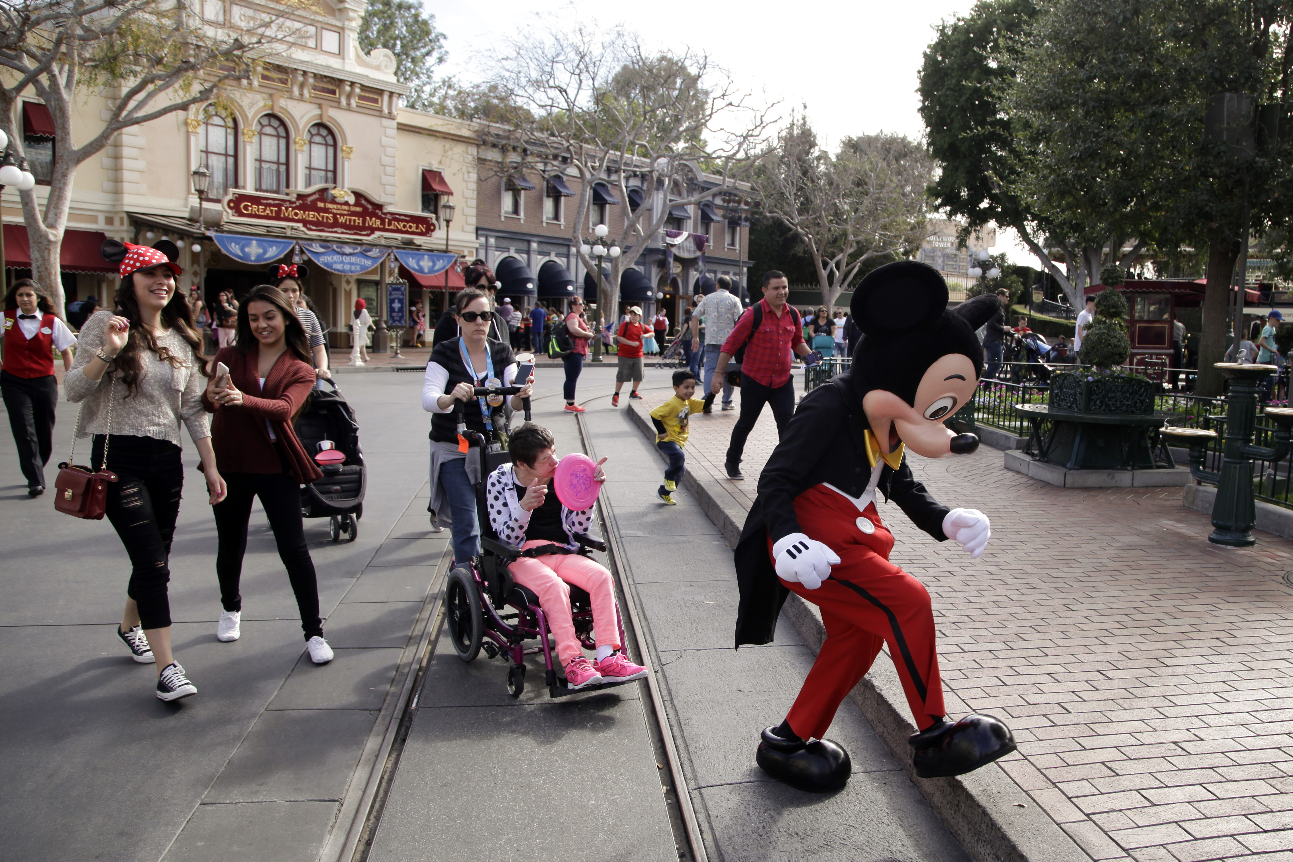 Visitors follow Mickey Mouse for photos at Disneyland, Jan. 22, 2015, in Anaheim, Calif. Disney is seeking approval from local officials to expand its California theme park offerings over the next four decades.