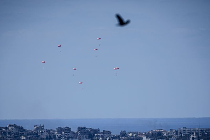 Parachutes drop supplies into the northern Gaza Strip, as seen from southern Israel, Sunday.