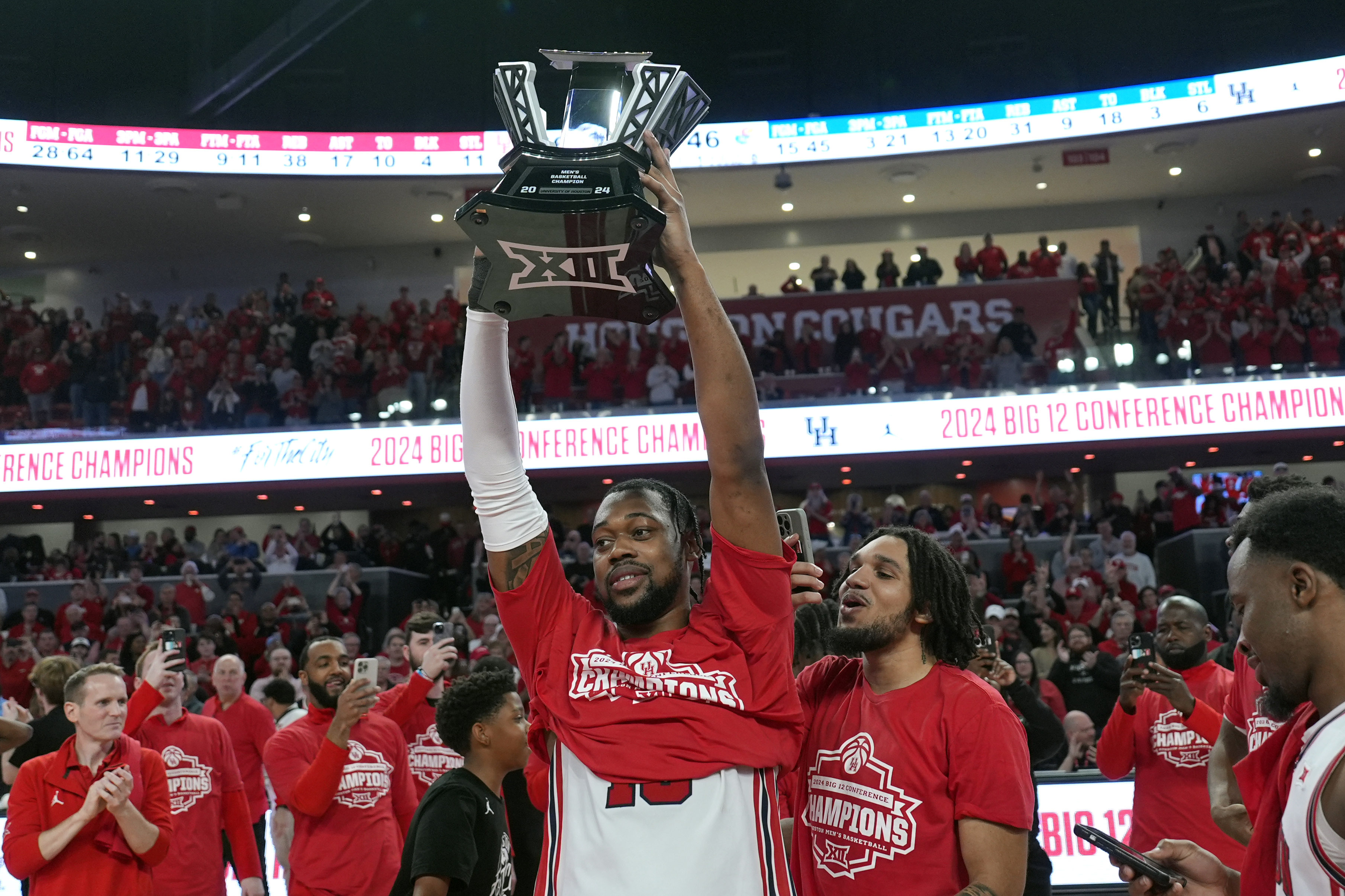 Houston's J'Wan Roberts, center, holds up the trophy after an NCAA college basketball game against Kansas Saturday, March 9, 2024, in Houston. Houston won 76-46 and finished the regular season as the Big 12 Conference Champions. 