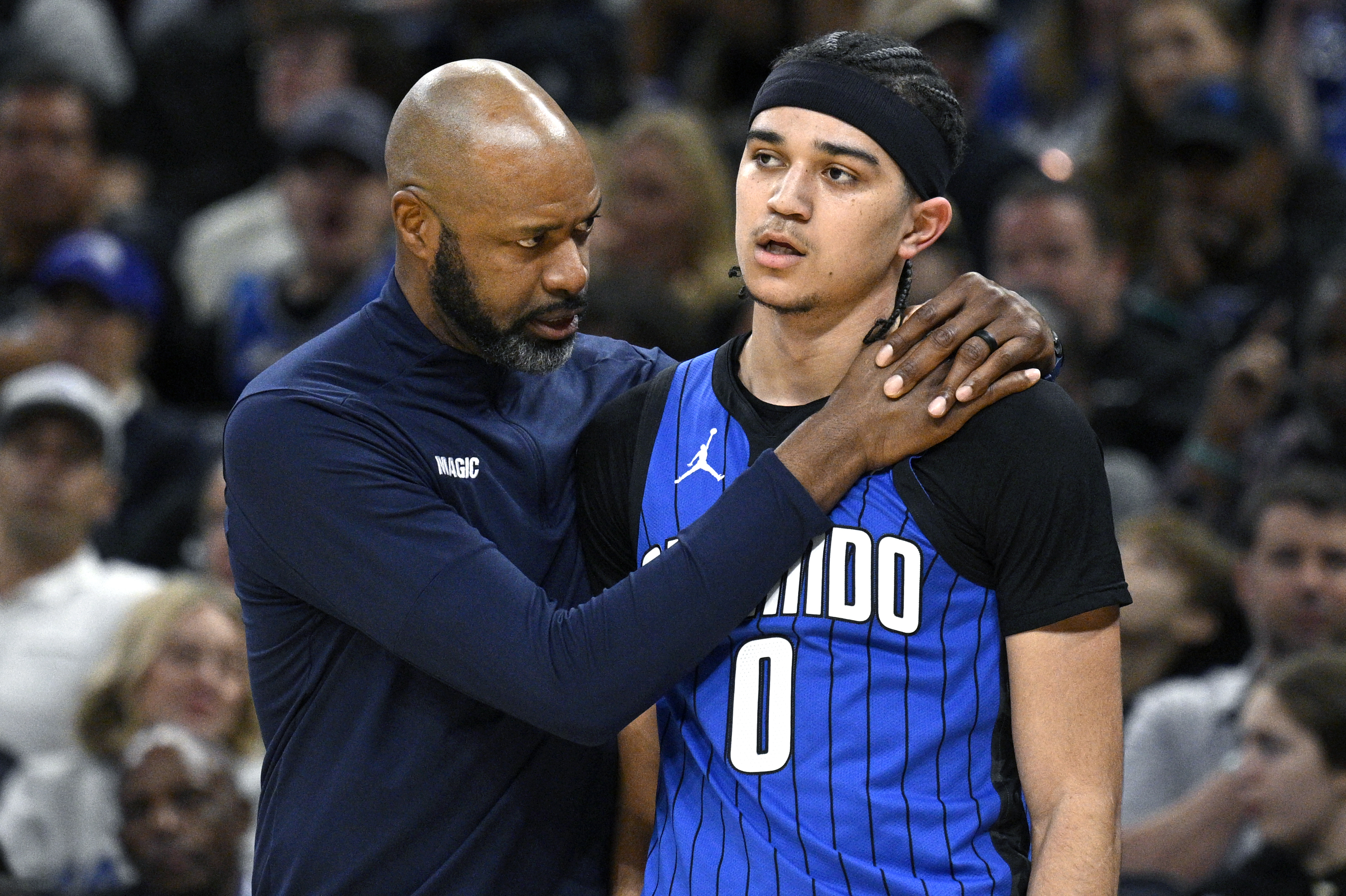 Orlando Magic head coach Jamahl Mosley, left, talks to guard Anthony Black (0) during the first half of an NBA basketball game against the Indiana Pacers, Sunday, March 10, 2024, in Orlando, Fla.