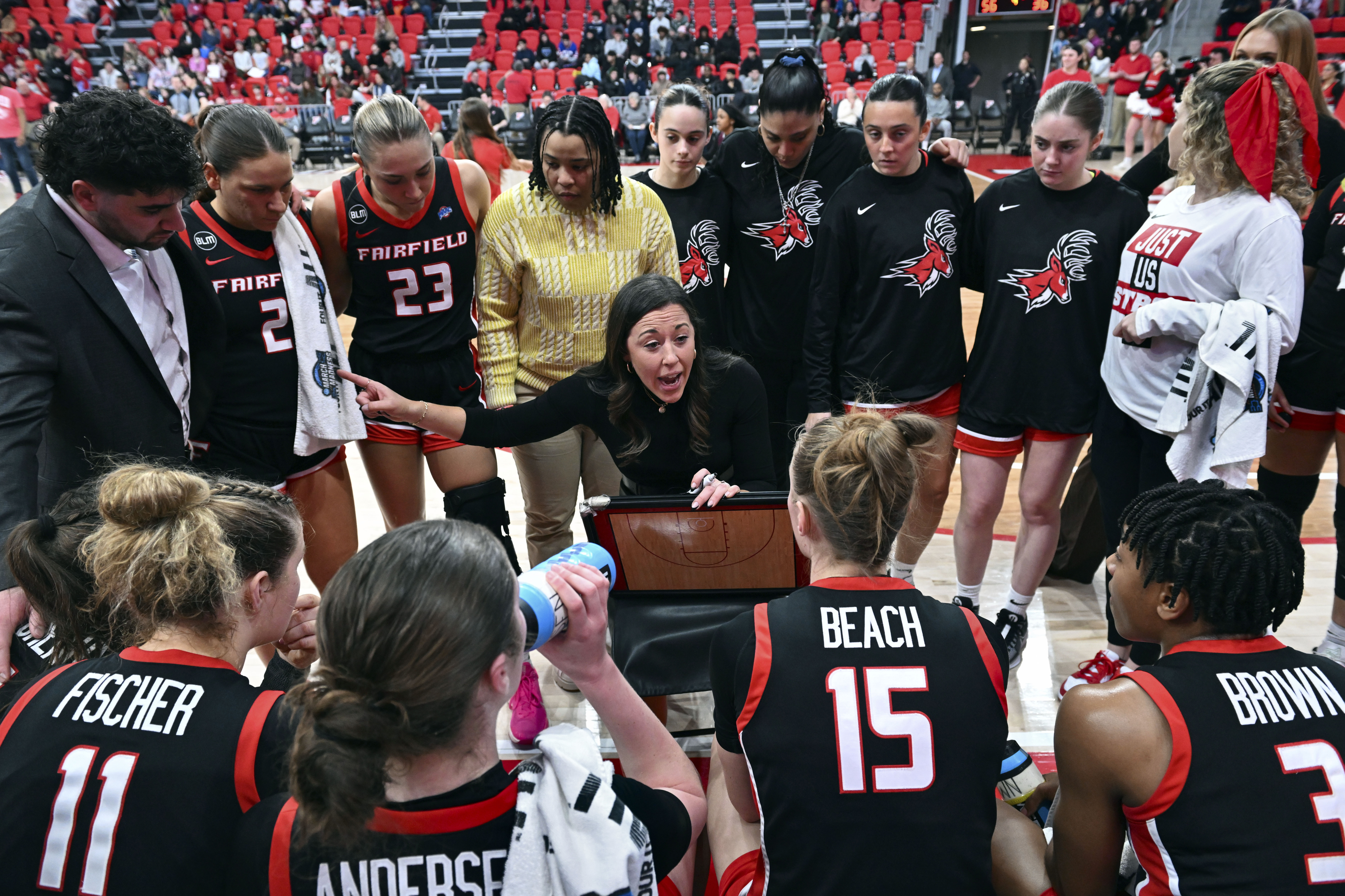 FILE - Fairfield coach Carly Thibault, center, speaks with her team during a timeout in an NCAA college basketball game, Feb. 8, 2024, in Fairfield, Conn. No. 25 Fairfield earned its first-ever ranking last week and became the eighth team to run through conference play undefeated. The Stags have a 26-game winning streak and their lone loss came to Vanderbilt, which is on the NCAA bubble. If Fairfield makes it to the final of the tournament on Saturday, March 16, 2024, and loses they might still have a shot to get an at-large bid.