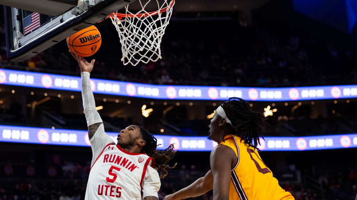 Utah Utes guard Deivon Smith (5) shoots a layup with Arizona State Sun Devils guard Kamari Lands (0) on defense during the game between the Utah Utes and the Arizona State Sun Devils in the first round of the 2024 Pac-12 men’s basketball tournament at the T-Mobile Arena in Las Vegas on Wednesday, March 13, 2024.