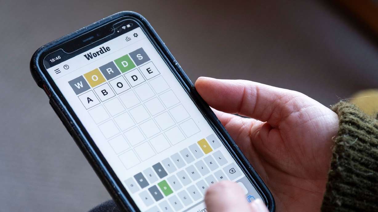 A woman plays Wordle on her phone in 2022. Wordle released its 1,000th puzzle on Friday.