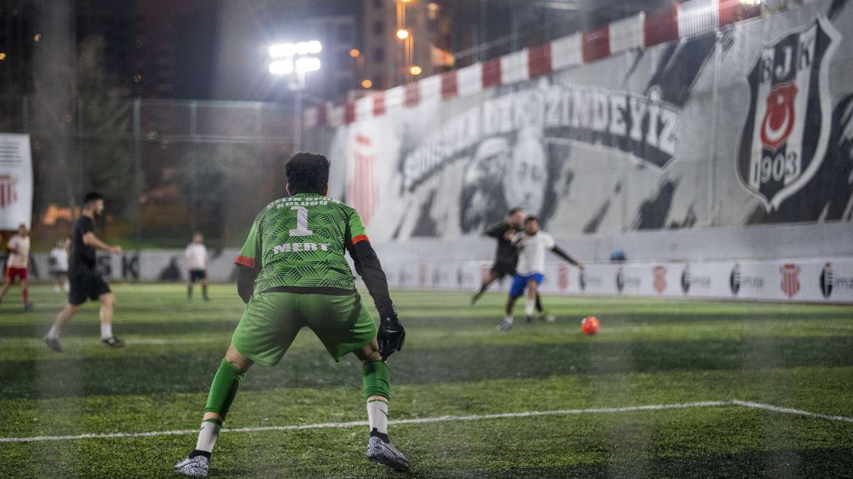 Amateur goalkeeper Mustafa Mert Olcer, left, follows the action during a recreational soccer "Astroturf" match in Istanbul, Turkey, Tuesday, March 5, 2024. More than a few times a week, the 18-year-old courier and passionate goalkeeper Mustafa Mert Olcer, gets a call from Rent-a-Goalkeeper to man a goalpost.