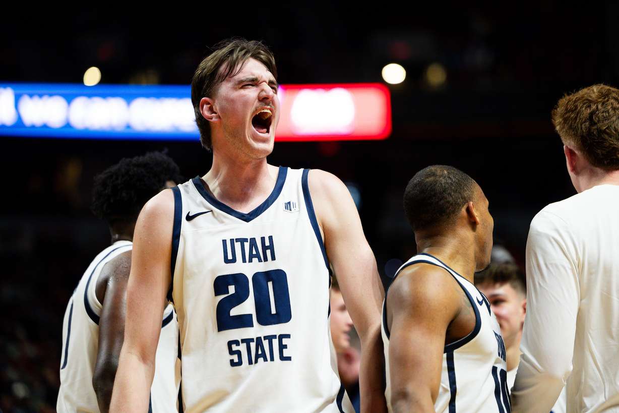 Utah State Aggies center Isaac Johnson (20) celebrates while coming off the floor for a timeout during the game between the Utah State Aggies and the Fresno State Bulldogs in the quarterfinals of the Mountain West 2024 Men's Basketball Championship at the Thomas & Mack Center in Las Vegas on Thursday, March 14, 2024. Utah State won the game 87-75 after going into overtime.