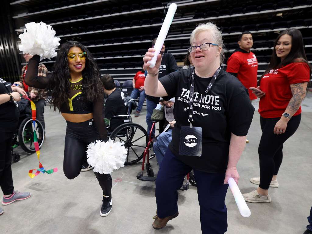 Jill Cardenas, Jazz dancer, dances with Debbie Parent during an event for TURN Community Services' Utah County day program participants, hosted by Ken Garff Automotive, at the Delta Center in Salt Lake City on Thursday.