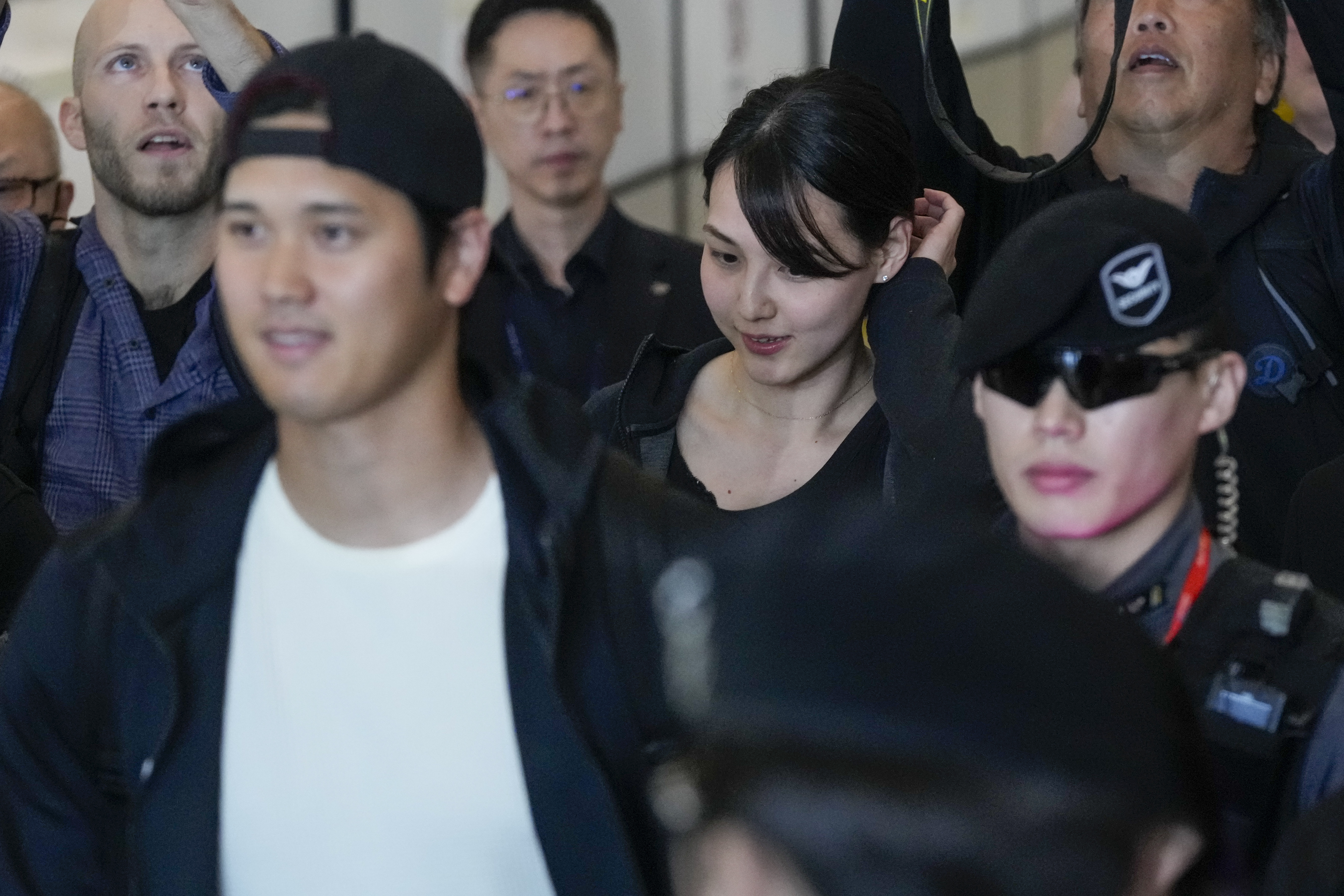 Mamiko Tanaka, center, wife of Los Angeles Dodgers Shohei Ohtani, left, walks with him through a terminal during the baseball team's arrival at Incheon International Airport, Friday, March 15, 2024, in Incheon, South Korea, ahead of the team's baseball series against the San Diego Padres.