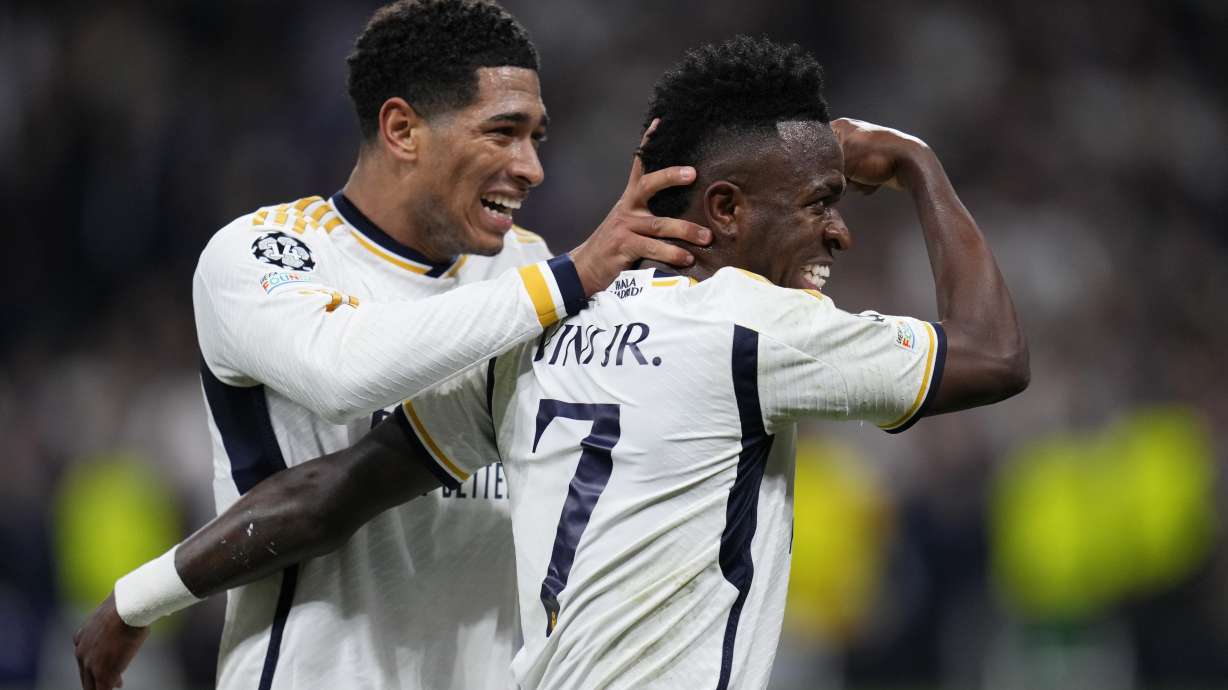 Real Madrid's Vinicius Junior, right, celebrates with his teammate Jude Bellingham after scoring his side's opening goal during the Champions League round of 16 second leg soccer match between Real Madrid and RB Leipzig at the Santiago Bernabeu stadium in Madrid, Spain, Wednesday, March 6, 2024.