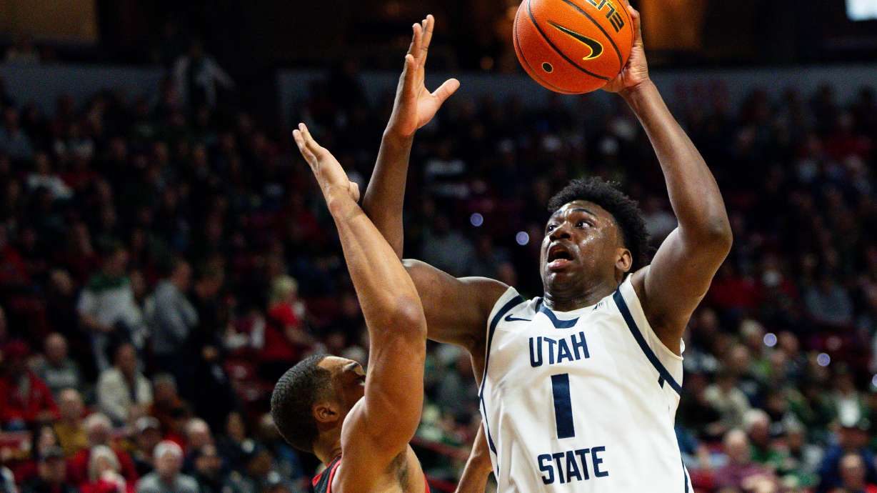 Utah State Aggies forward Great Osobor (1) shoots the ball with San Diego State Aztecs forward Jaedon LeDee (13) on defense during the game between the Utah State Aggies and the San Diego State Aztecs in the semifinals of the Mountain West 2024 Men's Basketball Championship at the Thomas & Mack Center in Las Vegas on Friday, March 15, 2024.