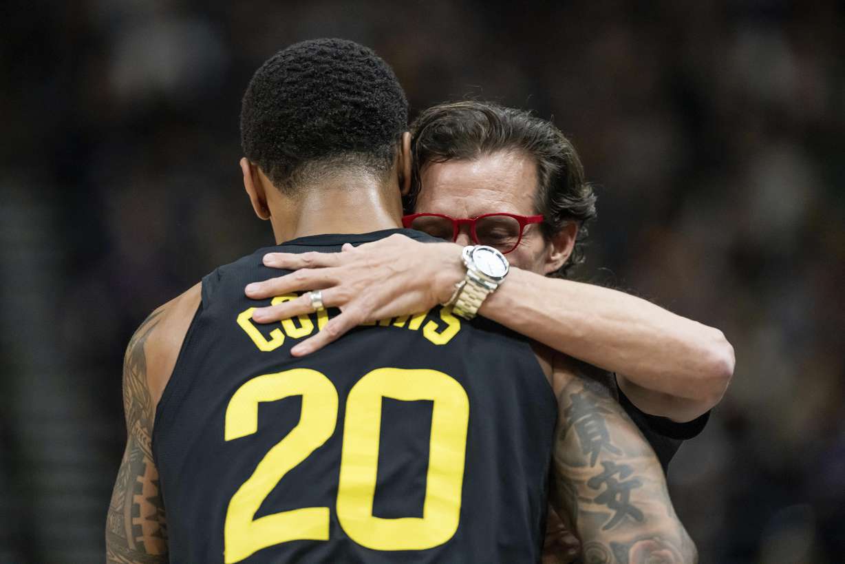 Utah Jazz forward John Collins (20) and Atlanta Hawks head coach Quin Snyder, right, embrace on the court during the first half of an NBA basketball game, Friday, March 15, 2024, in Salt Lake City. Friday night's game was Snyder's first time coaching back in Salt Lake City since departing as head coach of the Jazz.