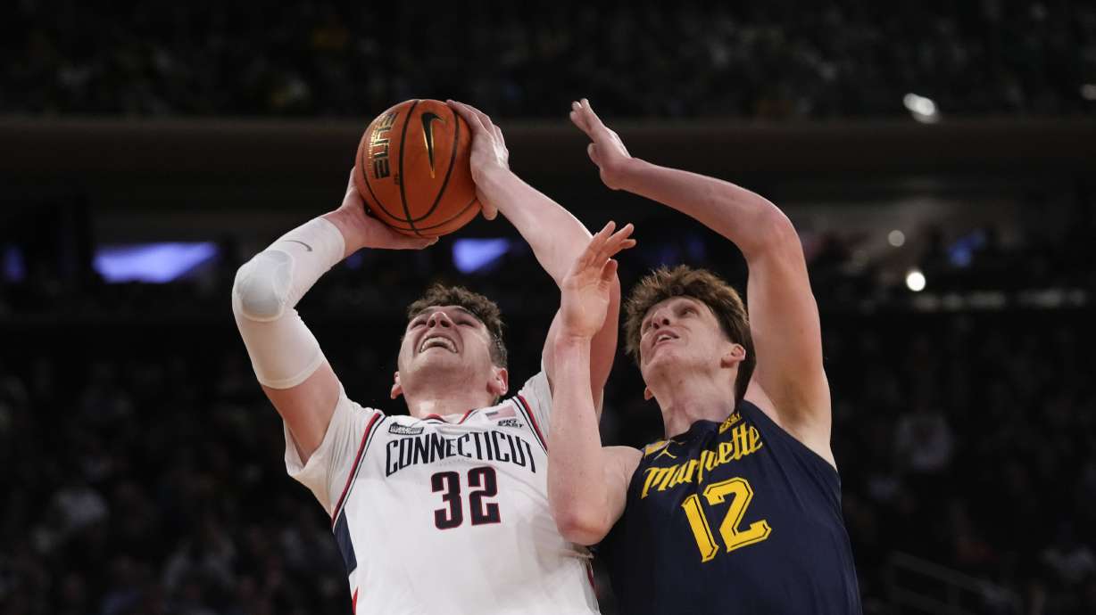 UConn center Donovan Clingan (32) goes to the basket against Marquette forward Ben Gold (12) during the first half of an NCAA college basketball game in the championship of the Big East Conference tournament, Saturday, March 16, 2024, in New York.