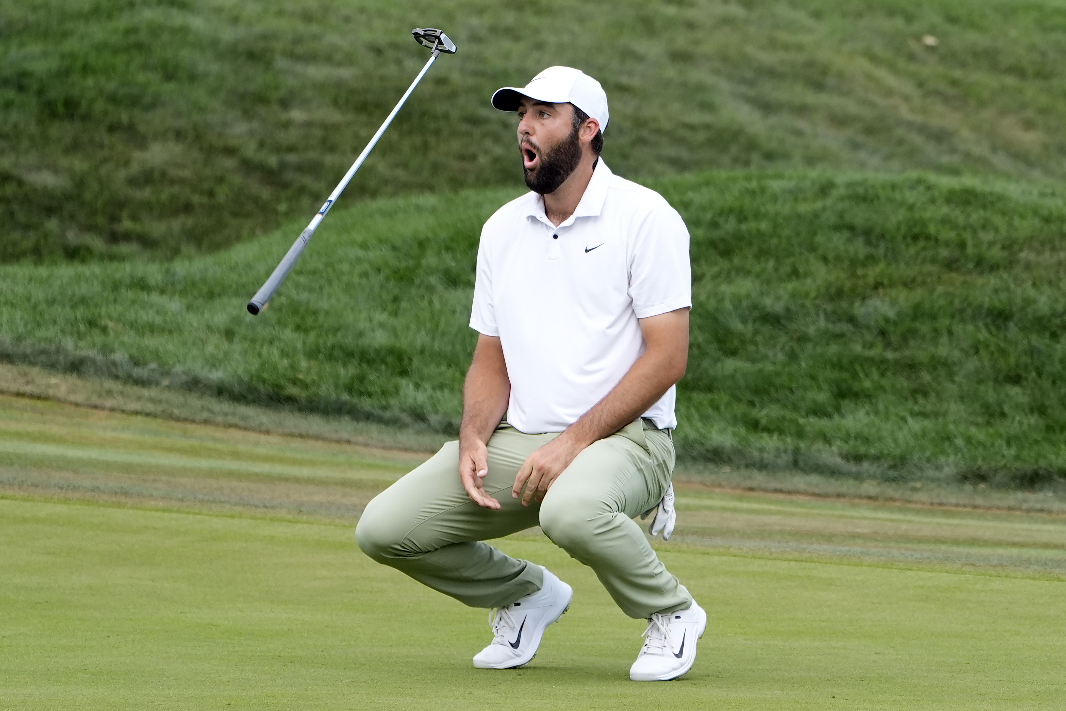 Scottie Scheffler flips his club after missing a birdie putt on the 18th green during the final round of The Players Championship golf tournament Sunday, March 17, 2024, in Ponte Vedra Beach, Fla.
