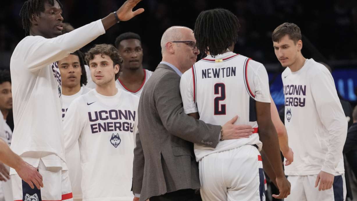 UConn head coach Dan Hurley, center, talks to guard Tristen Newton (2) as he comes to the bench during the first half of an NCAA college basketball game against Marquette in the championship of the Big East Conference tournament, Saturday, March 16, 2024, in New York.