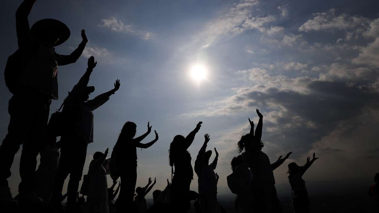Visitors hold their hands out to receive the sun's energy as they celebrate the spring equinox atop the Pyramid of the Sun in Teotihuacan, Mexico, March 21, 2019. Spring gets its official start Tuesday in the Northern Hemisphere.
