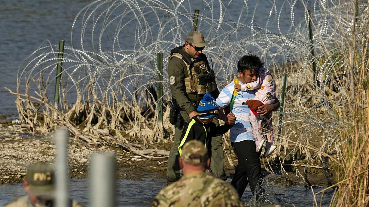 Migrants are taken into custody by officials at the Texas-Mexico border, Jan. 3, in Eagle Pass, Texas. The Supreme Court on Tuesday extended a stay on a new Texas law.