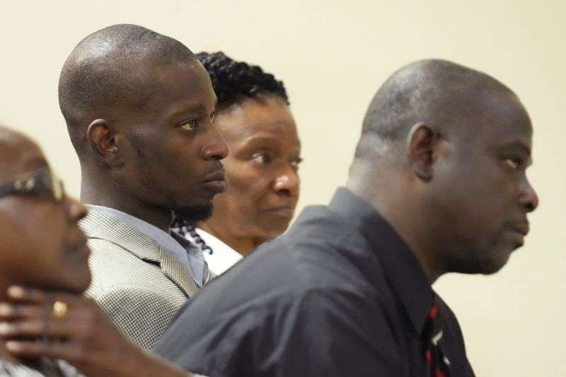 Michael Corey Jenkins, center, and Eddie Terrell Parker, right, listen as one of six former Mississippi law officers pleads guilty to state charges at the Rankin County Circuit Court in Brandon, Miss., Aug. 14, 2023. The two Black men were tortured by six former Mississippi law enforcement officers in a violent episode last year.