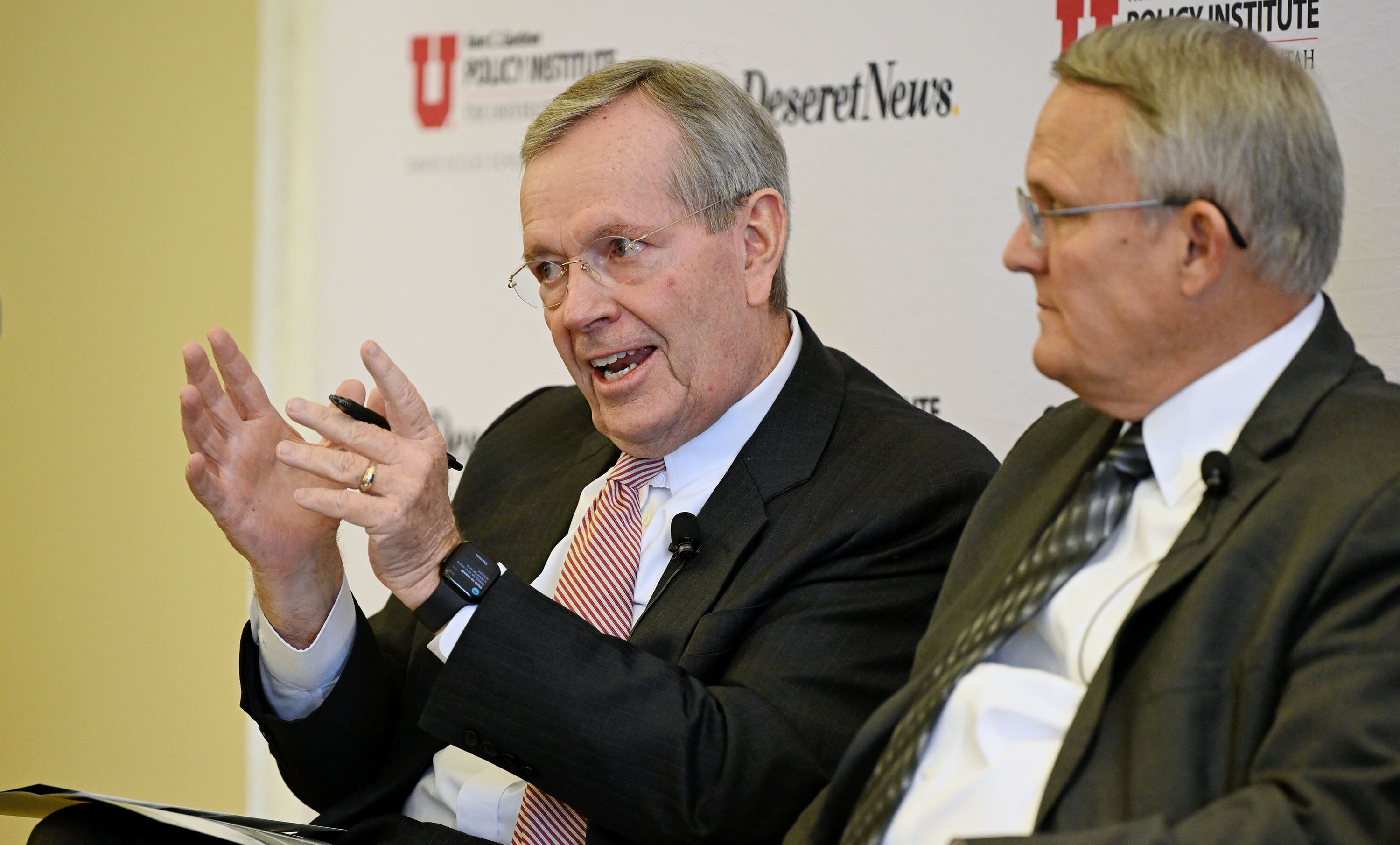 Former Gov. Michael Leavitt gestures while talking as Utah policy experts gather for discussions hosted by the University of Utah’s Kem C. Gardner Policy Institute at the Thomas S. Monson Center in Salt Lake City on March 18, 2024. Tom Warne, former UDOT director, listens at right.