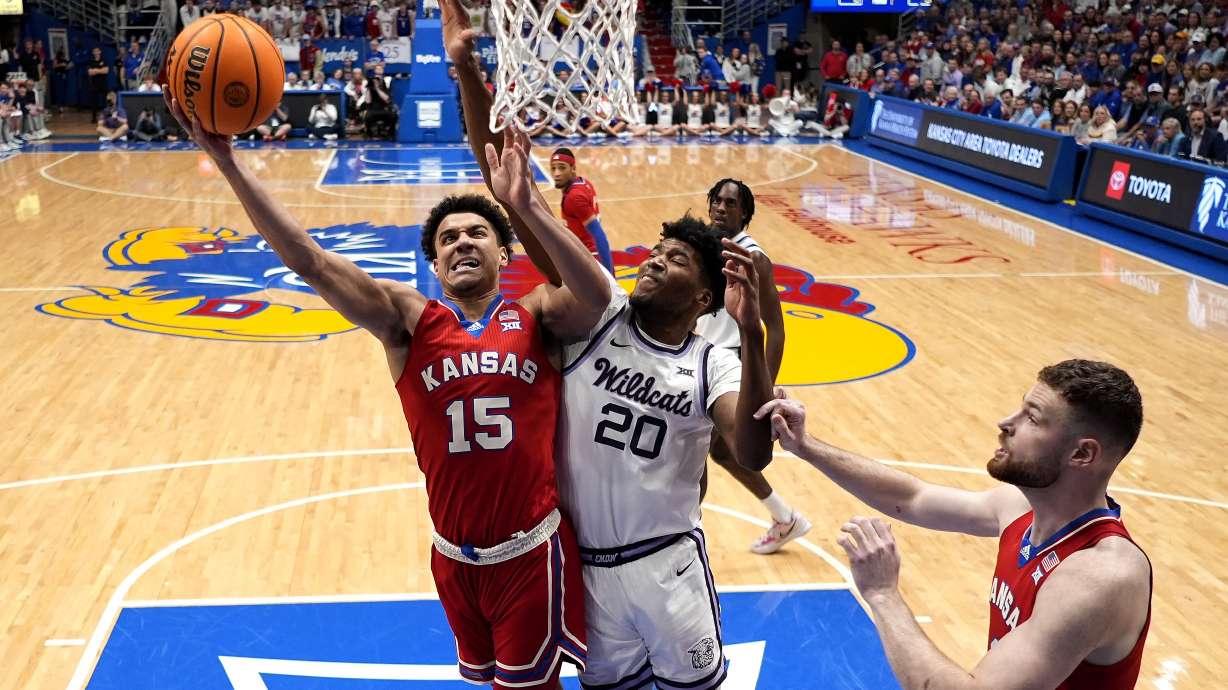 Kansas guard Kevin McCullar Jr. (15) shoots under pressure from Kansas State forward Jerrell Colbert (20) during the first half of an NCAA college basketball game Tuesday, March 5, 2024, in Lawrence, Kan.