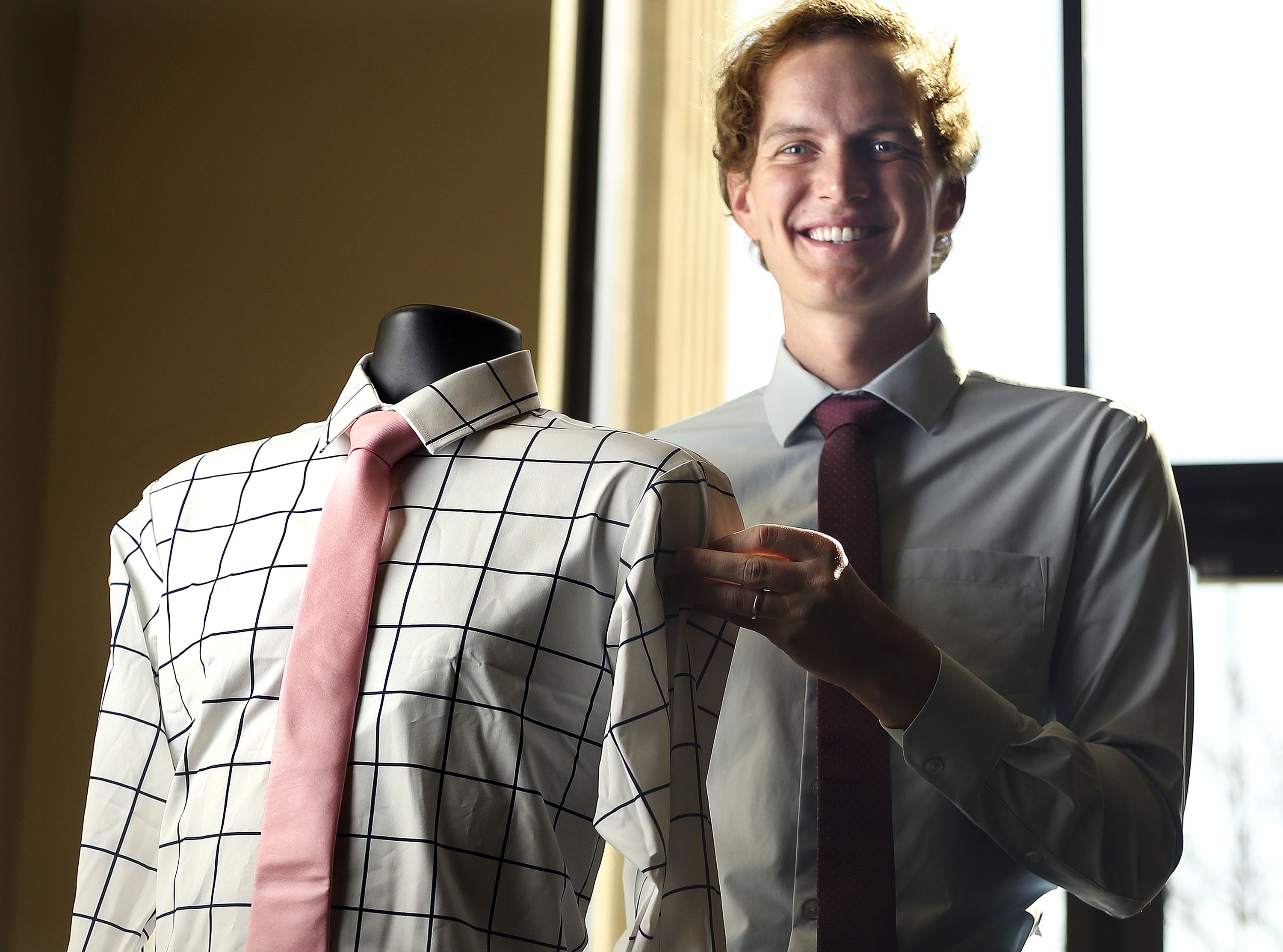Ben Perkins, owner of &Collar, holds a men’s dress shirt that is made out of recycled plastic at &Collar in Salt Lake City on April 8, 2021.