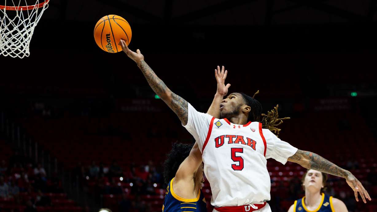 Utah Utes guard Deivon Smith (5) shoots the ball over UC Irvine Anteaters guard Pierre Crockrell II (3) during the game between the Utah Utes and the UC Irvine Anteaters in the NIT first round at the Jon M. Huntsman Center in Salt Lake City on Tuesday, March 19, 2024.