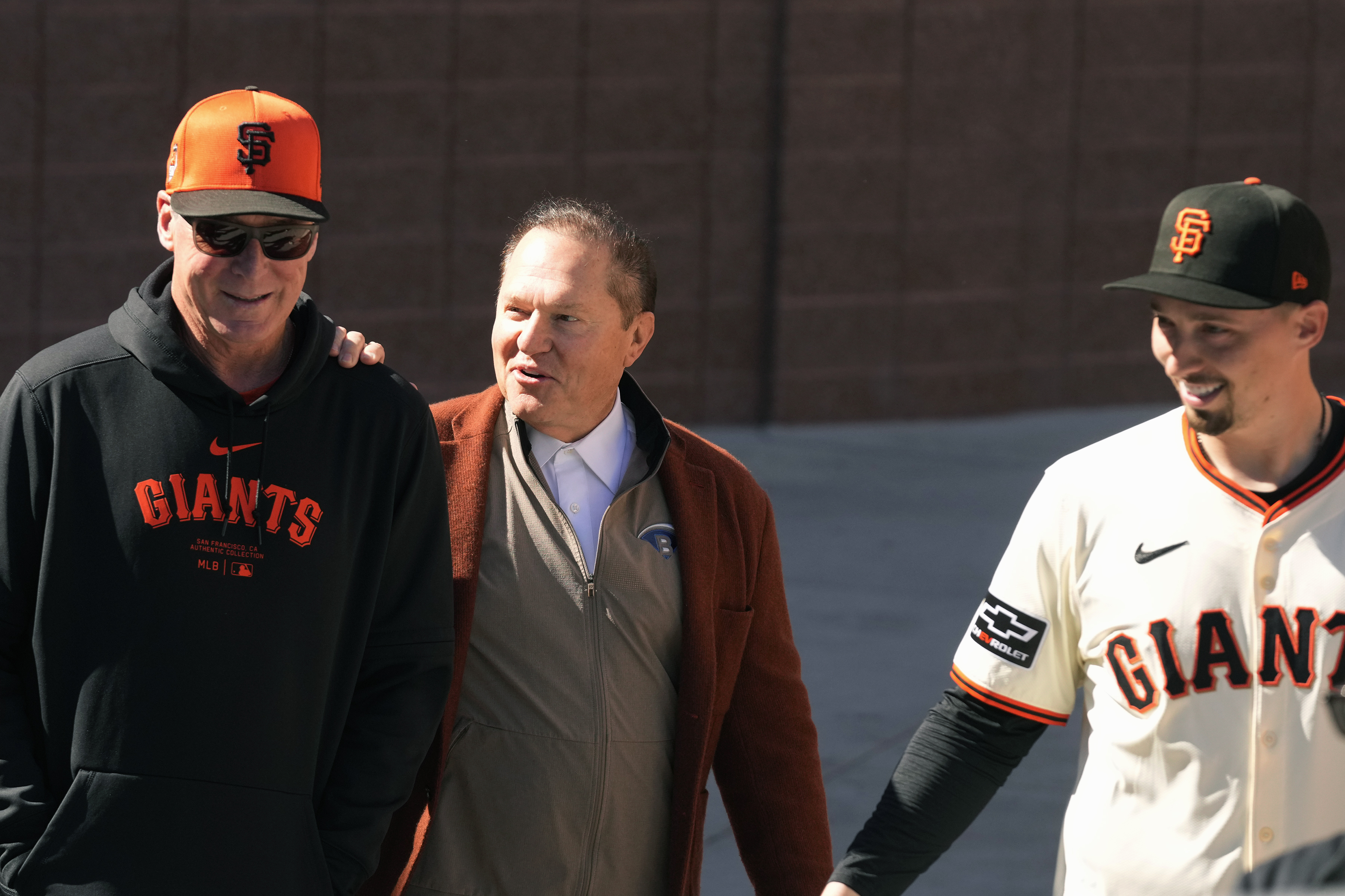 San Francisco Giants manager Bob Melvin, left, smiles as he talks with agent Scott Boras, center, prior to new Giants pitcher Blake Snell, right, being introduced during a baseball news conference Wednesday, March 20, 2024, in Scottsdale, Ariz. 