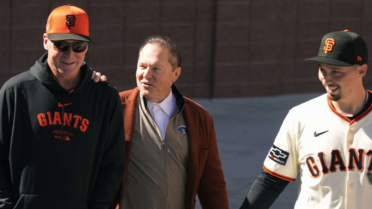 San Francisco Giants manager Bob Melvin, left, smiles as he talks with agent Scott Boras, center, prior to new Giants pitcher Blake Snell, right, being introduced during a baseball news conference Wednesday, March 20, 2024, in Scottsdale, Ariz.
