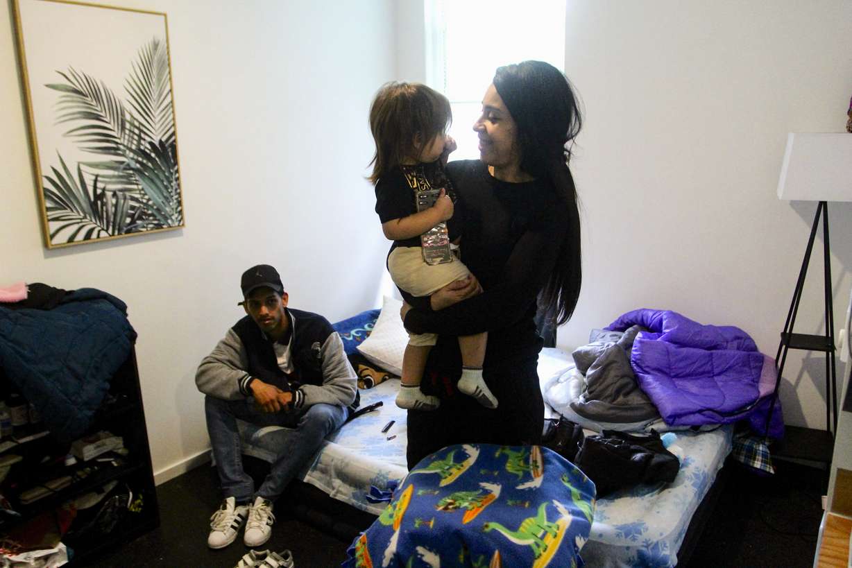 Barbara Peraza-Garcia holds her 2-year-old daughter, Frailys, while her partner Franklin Peraza sits on their bed in their 'micro apartment' in Seattle on March 11.