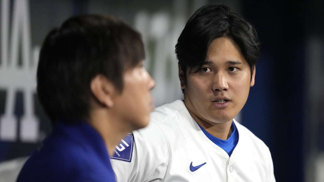 Los Angeles Dodgers' designated hitter Shohei Ohtani, right, chats with his interpreter Ippei Mizuhara during an exhibition baseball game between Team Korea and the Los Angeles Dodgers at the Gocheok Sky Dome in Seoul, South Korea, Monday, March 18, 2024. Ohtani’s interpreter and close friend has been fired by the Dodgers following allegations of illegal gambling and theft from the Japanese baseball star.