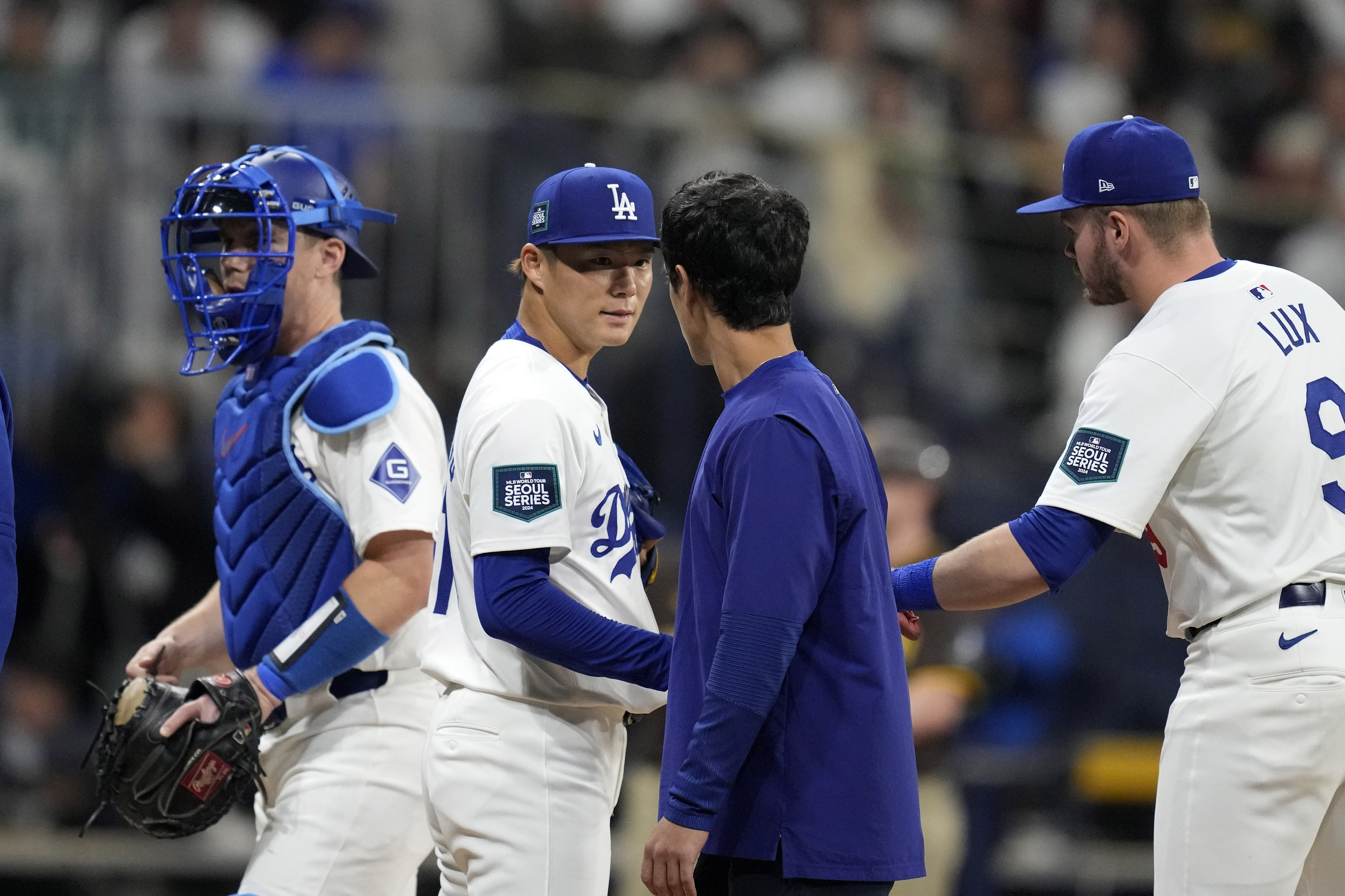 Los Angeles Dodgers starting pitcher Yoshinobu Yamamoto, second from left, speaks with interpreter Will Ireton, second from right, as catcher Will Smith, left, and second baseman Gavin Lux during the first inning of a baseball game at the Gocheok Sky Dome in Seoul, South Korea Thursday, March 21, 2024, in Seoul, South Korea. 