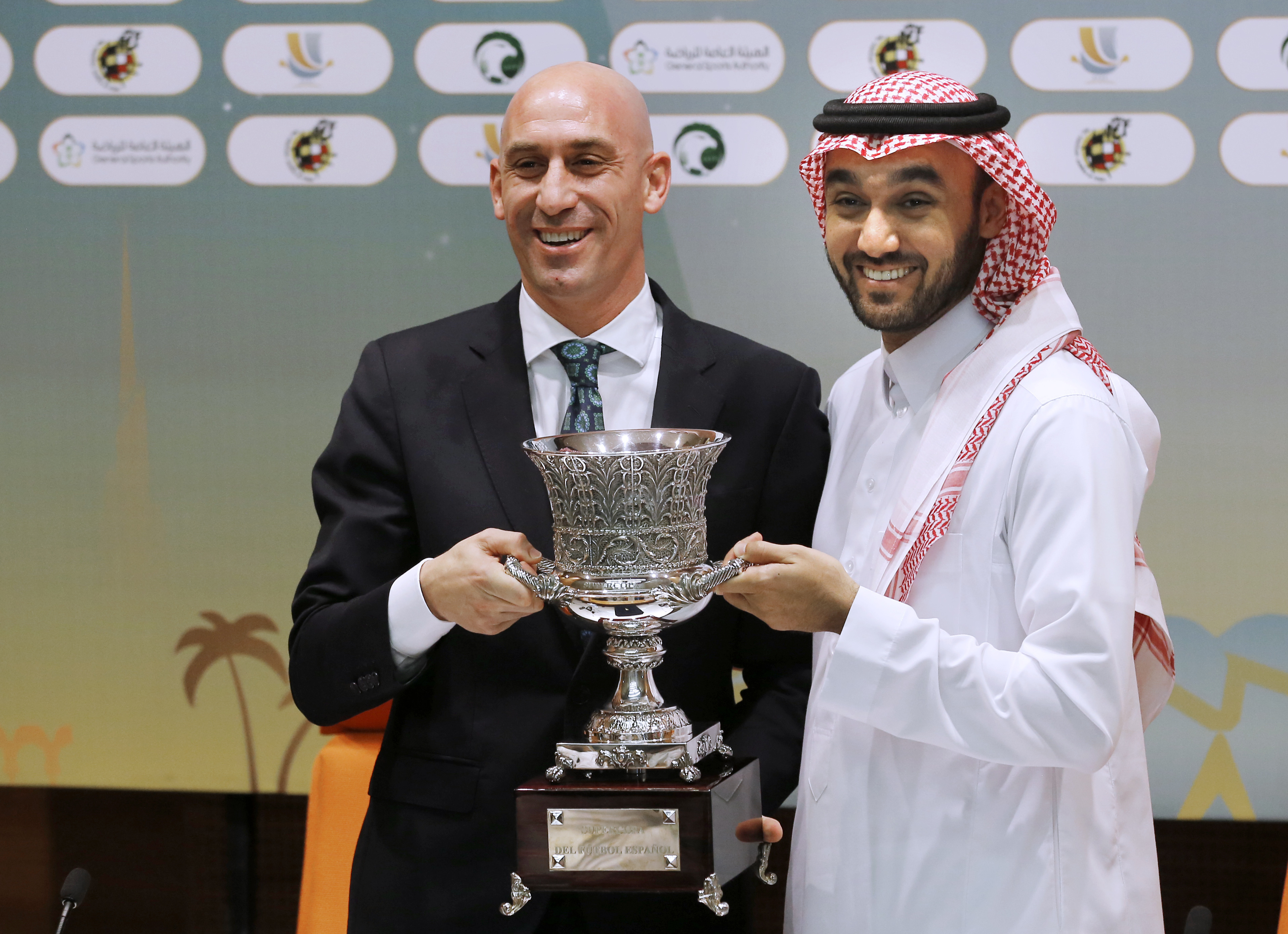 FILE - President of the Spanish Federation, Luis Rubiales, left, and Saudi General Sport Authority GSA chairman Prince Abdulaziz bin Turki Al-Faisal carry the Spanish super cup during a press conference in Jiddah Saudi Arabia, Wednesday, Dec. 18, 2019. Spanish police have arrested at least six people and raided the offices of the Spanish soccer federation as part of a corruption and money laundering investigation that includes suspicions regarding the federation’s deal with Saudi Arabia to take the Spanish Super Cup to the Middle Eastern country. Spain’s Guardia Civil said that they raided the federation’s offices near Madrid and a residence belonging to former federation president Luis Rubiales in the southern city of Granada. Police said that Rubiales was not among the six arrested. 