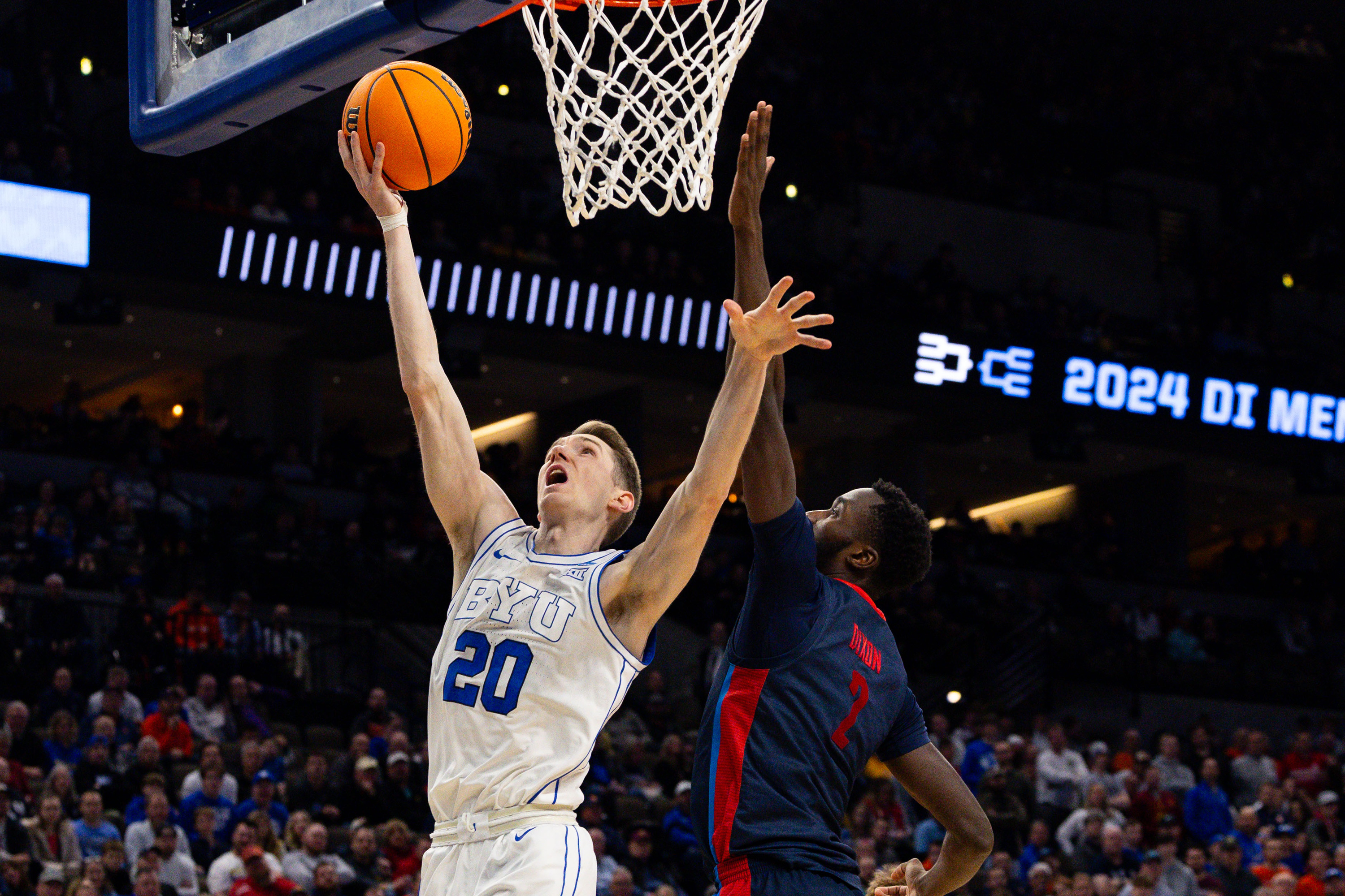 Brigham Young Cougars guard Spencer Johnson (20) shoots the ball with Duquesne Dukes forward David Dixon (2) on defense during the game between the Brigham Young Cougars and the Duquesne Dukes in the first round of the 2024 NCAA Tournament at the CHI Health Center in Omaha on Thursday, March 21, 2024. - Megan Nielsen, Deseret News