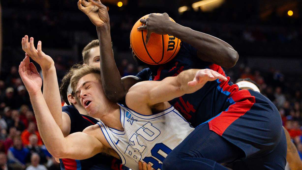 Brigham Young guard Dallin Hall (30) and Duquesne forward Fousseyni Drame (34) battle for the ball during the game between the Brigham Young Cougars and the Duquesne Dukes in the first round of the 2024 NCAA Tournament at the CHI Health Center in Omaha on Thursday, March 21, 2024.