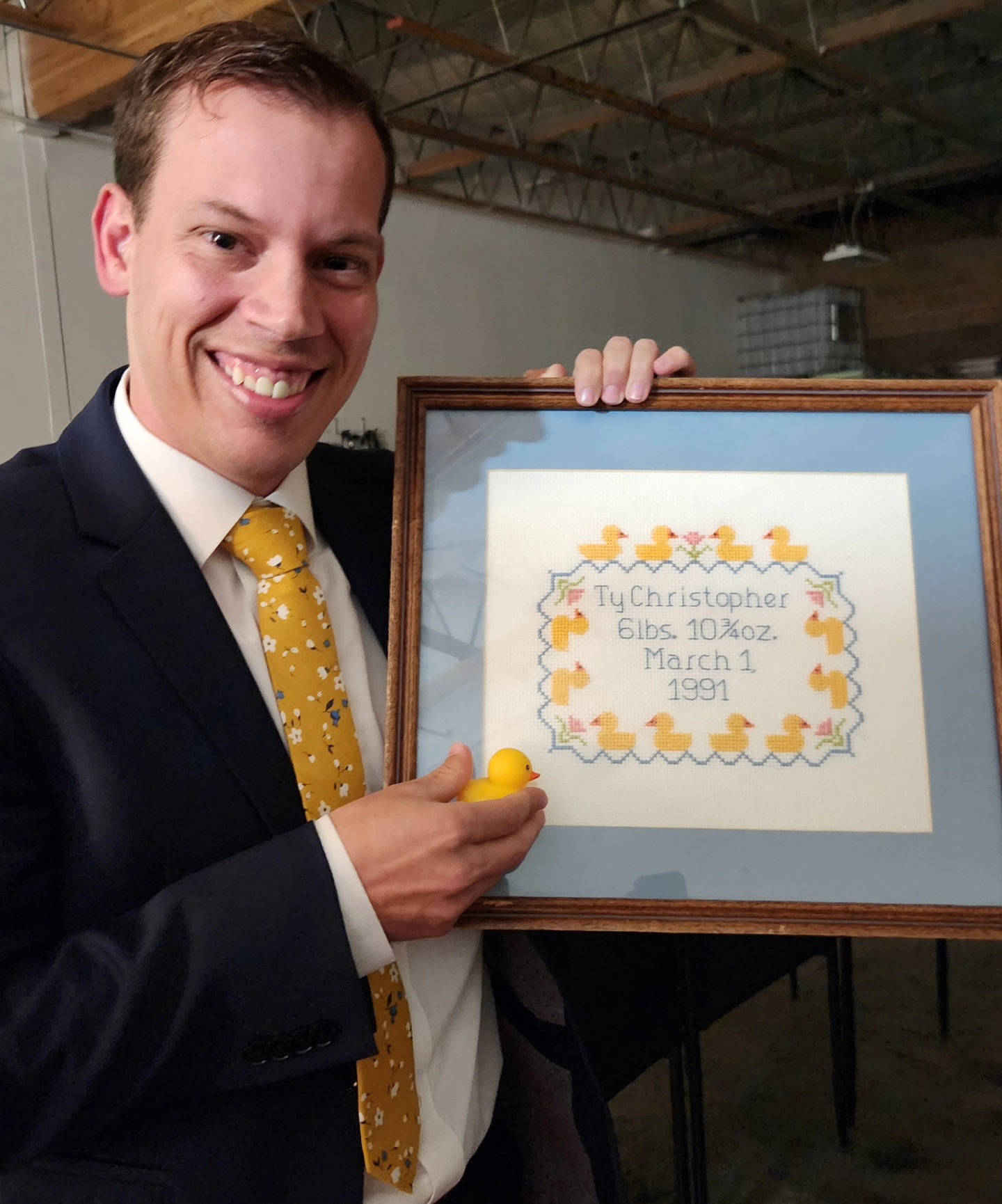Ty Nelson poses with his cross-stitch that created a cult-like following of college students at a movie premiere in Orem on March 13.