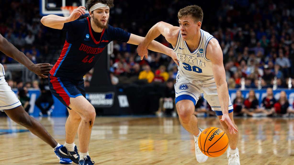 Brigham Young Cougars guard Dallin Hall (30) dribbles the ball down the court with Duquesne Dukes guard Jake DiMichele (44) on defense during the game between the Brigham Young Cougars and the Duquesne Dukes in the first round of the 2024 NCAA Tournament at the CHI Health Center in Omaha on Thursday, March 21, 2024.