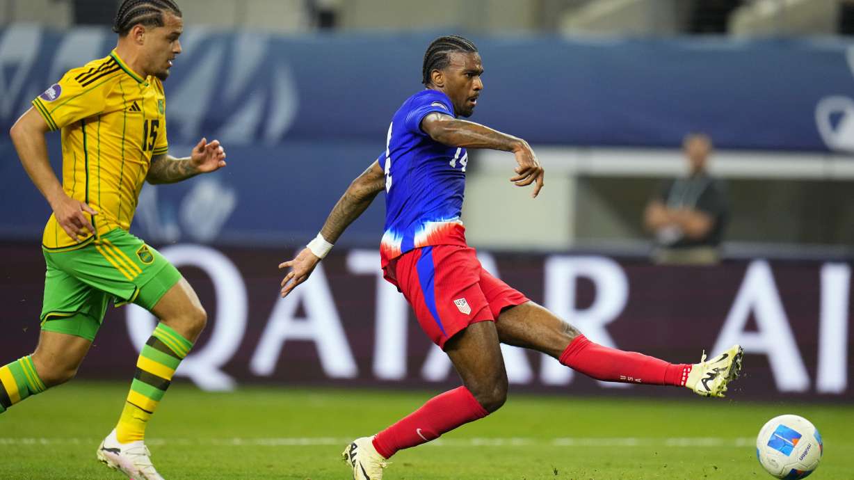 United States' Haji Wright, right, shoots a goal in front of Jamaica's Joel Latibeaudiere during the first overtime half of a CONCACAF Nations League semifinals soccer match, Thursday, March 21, 2024, in Arlington, Texas.