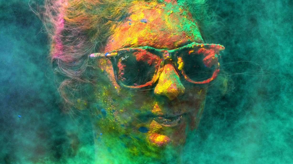 A woman smeared with colors celebrates Holi, the Hindu festival of colors, in Mumbai, India, March 7, 2023.