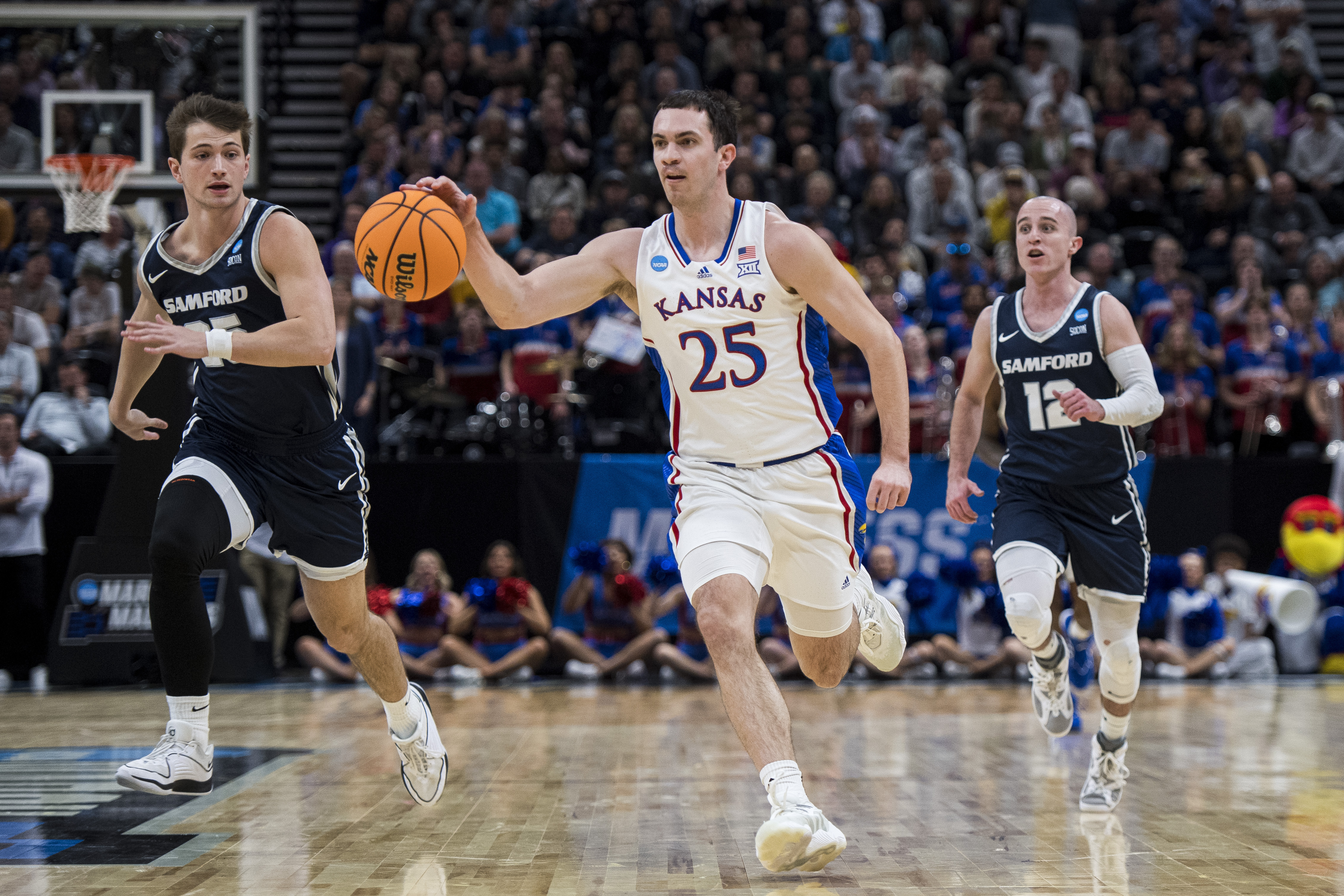 Kansas guard Nicolas Timberlake (25) brings the ball up-court between Samford forward Nathan Johnson, left, and guard Dallas Graziani (12) during the first half of a first-round college basketball game in the NCAA Tournament in Salt Lake City, Thursday, March 21, 2024. 