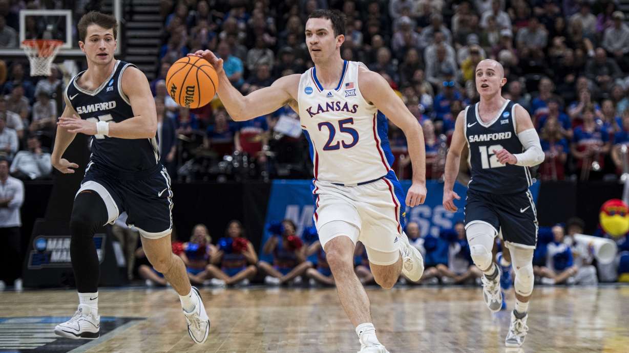 Kansas guard Nicolas Timberlake (25) brings the ball up-court between Samford forward Nathan Johnson, left, and guard Dallas Graziani (12) during the first half of a first-round college basketball game in the NCAA Tournament in Salt Lake City, Thursday, March 21, 2024.
