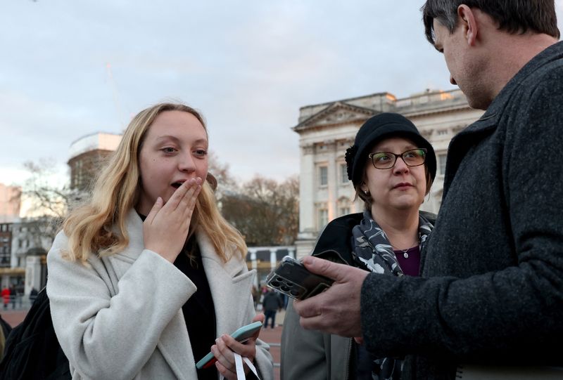 People react to an announcement about the health of Britain's Catherine, Princess of Wales, outside Buckingham Palace in London, Britain, on Friday.