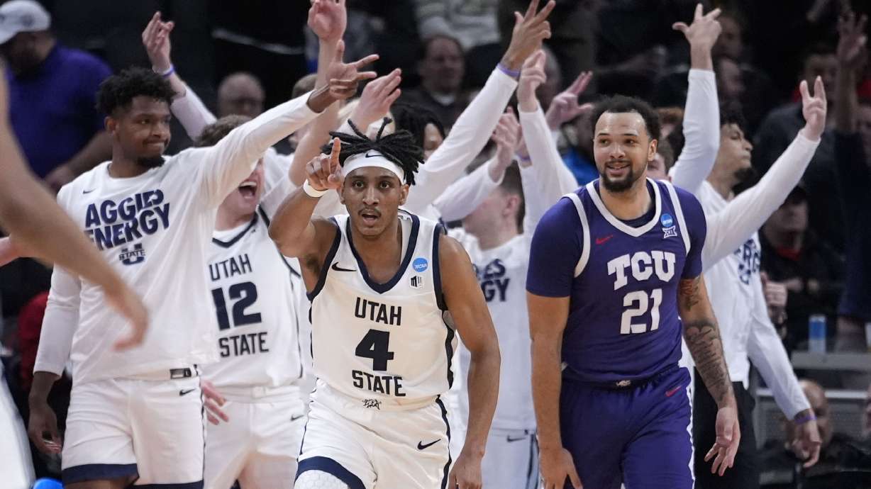 Utah State guard Ian Martinez (4) celebrates in front of TCU forward JaKobe Coles (21) after making a three-point basket in the second half of a first-round college basketball game in the NCAA Tournament, Friday, March 22, 2024, in Indianapolis.