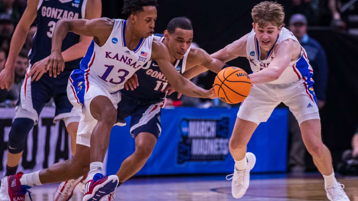 Kansas guard Elmarko Jackson, left, Gonzaga guard Nolan Hickman, center, and Kansas guard Johnny Furphy, right, fight for a loose ball during a game between Gonzaga and Kansas in the second round of the NCAA men's basketball tournament at the Delta Center in Salt Lake City on Saturday.