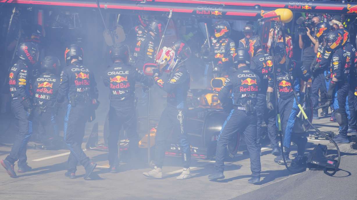 Red Bull driver Max Verstappen of the Netherlands walks from his car as his mechanics work to put out a fire during the Australian Formula One Grand Prix at Albert Park, in Melbourne, Australia, Sunday, March 24, 2024.