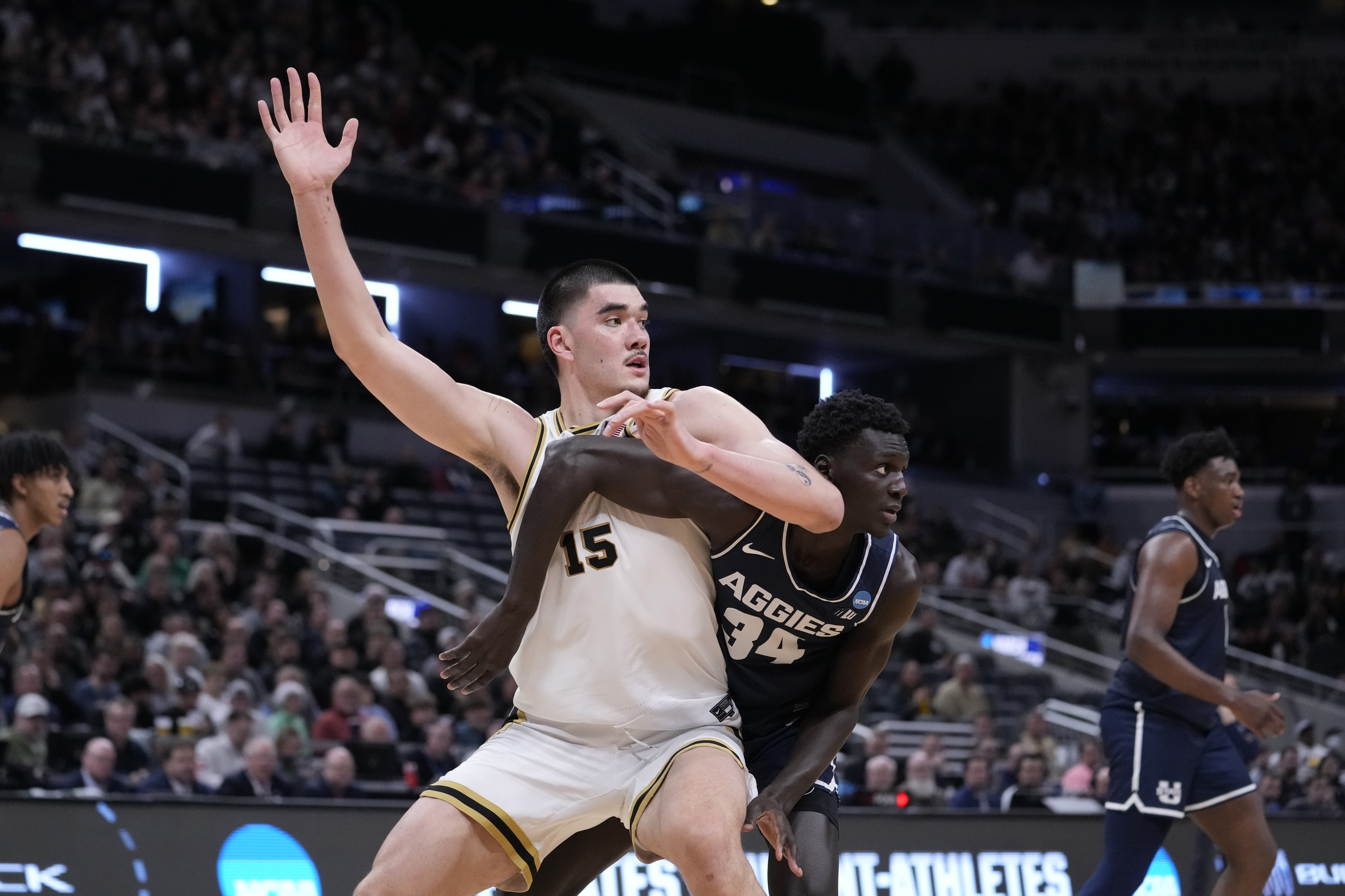 Purdue's Zach Edey (15) looks for a pass under the basket as Utah State's Kalifa Sakho (34) defends during the second half of a second-round college basketball game in the NCAA Tournament, Sunday, March 24, 2024 in Indianapolis. 